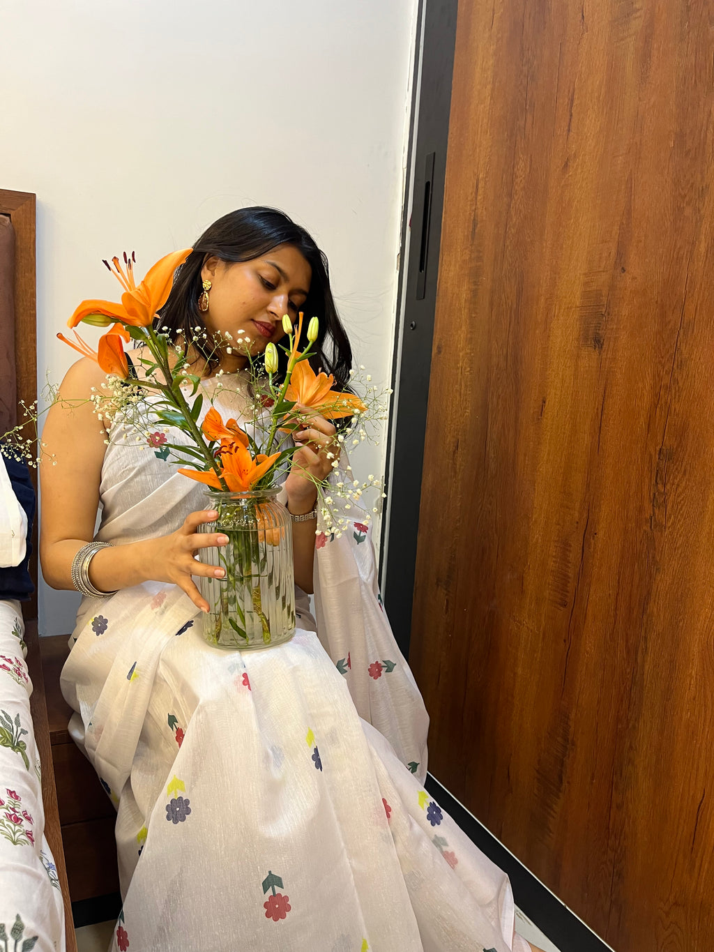 Woman in white cotton saree with flower print. Very pretty cotton saree.