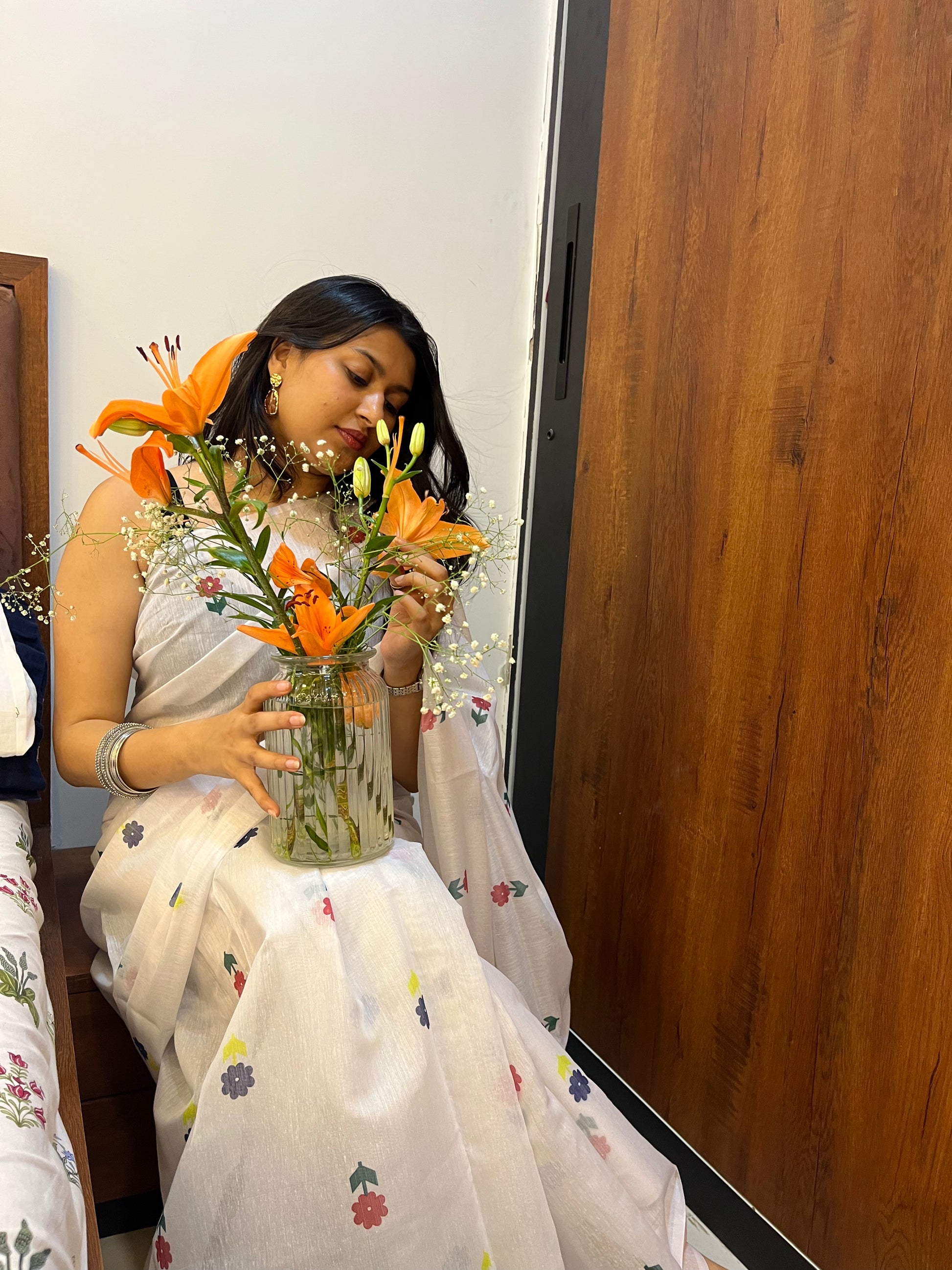 Woman in white cotton saree with flower print. Very pretty cotton saree.